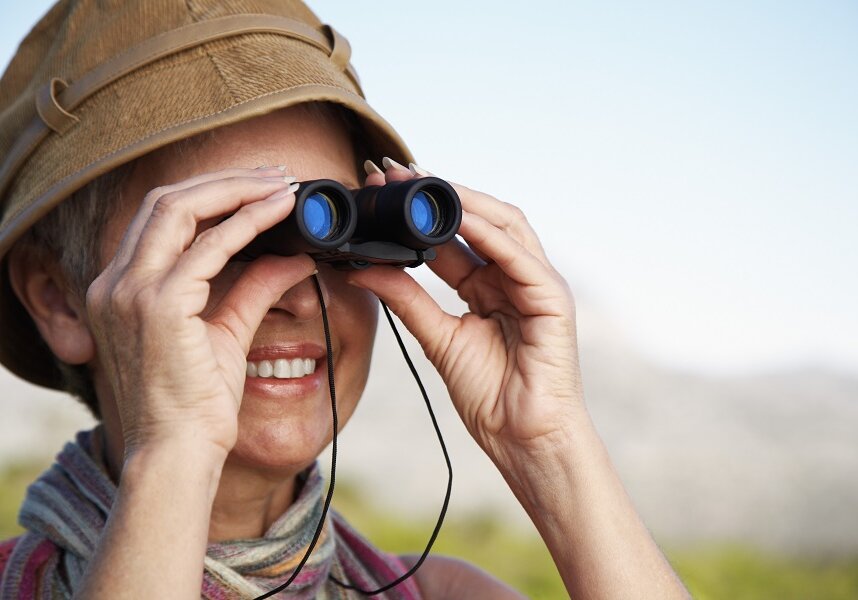 woman with binoculars watching birds